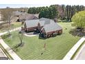 Lovely red brick home with manicured lawn, mature trees and an American flag at 1000 Maria Dr, Mcdonough, GA 30253