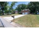 Street view of a well maintained home with brick facade, a large driveway, and lush landscaping at 3216 Pheasant Dr, Decatur, GA 30034