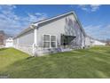 A backyard view with green grass, a covered patio, and gray siding on the house at 3201 Azteca Way, Dacula, GA 30019