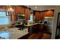 Modern kitchen with granite countertops, stainless steel appliances, wooden cabinets, and a double window for natural light at 5142 Rock Eagle Dr, Stone Mountain, GA 30083