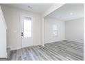 Bright entryway featuring stylish gray wood floors, white walls, and a frosted glass door at 3754 Saddle Bag Ct, Dacula, GA 30019