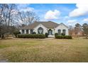 Charming painted brick home featuring manicured landscaping, a blue front door, and elegant architectural details at 3403 Bill Gardner Pkwy, Locust Grove, GA 30248