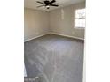 Neutral bedroom with new carpet, a window, and a modern ceiling fan at 95 Grove Creek Dr, Locust Grove, GA 30248