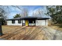 Charming ranch-style house with a bright yellow front door and an attached one-car garage at 95 Grove Creek Dr, Locust Grove, GA 30248