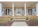 Inviting front porch featuring stone detail, white columns and space for rocking chairs at 6360 Brookline Ct, Cumming, GA 30040