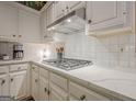 Modern kitchen featuring stainless steel hood vent, white cabinets, and sleek countertops at 6360 Brookline Ct, Cumming, GA 30040