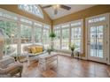 Bright sunroom with tile floors, multiple windows, and cozy wicker furniture at 6360 Brookline Ct, Cumming, GA 30040