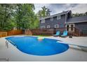 Backyard features an in-ground pool, wooden deck, lounge chairs, and partial privacy fence at 317 Lucan Way, Riverdale, GA 30274
