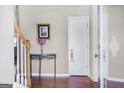 Elegant entryway featuring hardwood floors, table with flower vase, and white interior door at 3867 Summer Kitchen Way, Lilburn, GA 30047