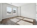 Bright bedroom featuring wood-look floors, white walls, and large windows at 106 Cowpen Ct, Walnut Grove, GA 30052