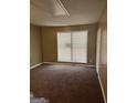 View of empty bedroom with tan walls, carpet and a window with blinds at 186 Governors Dr, Forest Park, GA 30297