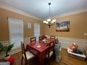 Well-lit dining room with classic chandelier, wainscoting and bright windows at 306 Oakwind Way, Canton, GA 30114