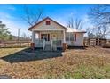 Quaint home showcasing a covered porch, red shutters, and a fenced yard at 5700 Mount Zion Rd, Waco, GA 30182
