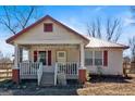 Inviting white home featuring a cozy porch, red shutters, and string lights at 5700 Mount Zion Rd, Waco, GA 30182