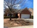Charming brick home featuring an attached two-car garage and well-maintained front yard at 8537 Spivey Village Trl, Jonesboro, GA 30236