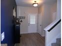 Bright entryway with neutral walls, dark blue accent wall and light wood-look flooring at 620 Calvo Run, Mcdonough, GA 30253