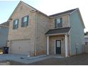 Two-story brick home featuring an attached garage and dark green shutters at 620 Calvo Run, Mcdonough, GA 30253