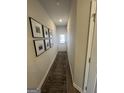 Hallway with decorative framed artwork and a long rug leading to a white front door at 11569 Kimberly Way # 26, Hampton, GA 30228