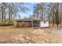 Backyard view of a brick home with a screened in porch and detached garage at 1115 Highway 54 East, Fayetteville, GA 30214