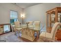 Well-lit dining room with a glass table, neutral-toned chairs, wooden floors, and a cabinet, creating a welcoming atmosphere at 9068 Jim Purcell Dr, Covington, GA 30014