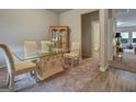 Well-lit dining room with a glass table, neutral-toned chairs, wooden floors, and a cabinet, creating a welcoming atmosphere at 9068 Jim Purcell Dr, Covington, GA 30014