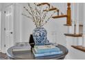 Foyer table with floral arrangement, showcasing elegant decor, near the staircase with wooden banisters at 407 Blue Smoke Trl, Peachtree City, GA 30269