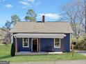 Inviting blue home with a covered front porch and a bench for relaxation at 340 Cedar St, Social Circle, GA 30025