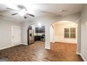 Open-concept living room showcases wood-look floors, arched doorways, and seamless flow to the kitchen at 323 Lauren Dr, Fairburn, GA 30213