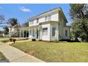Classic two-story home with a covered front porch and mature trees, situated on a spacious lot at 76 College St, Mcdonough, GA 30253