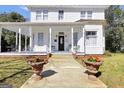 Charming two-story home with a welcoming front porch, enhanced by decorative planters and a well-kept yard at 76 College St, Mcdonough, GA 30253