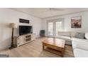 Spacious living room featuring light-colored wood floors, a large sectional, and double doors at 3529 Essex Ave # 75, Atlanta, GA 30339