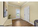 A sunlit foyer with wood floors, white trim, and a stylish bench, creating a welcoming entrance at 2377 Aukerman Trce # 82, Hampton, GA 30228