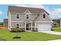 Charming two-story home with gray siding, brick accents, and a two-car garage at 1037 Claas Way, Locust Grove, GA 30248