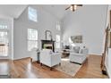 Bright living room with soaring ceilings, a fireplace, and large windows allowing ample natural light at 1654 Summersweet Ln, Dacula, GA 30019