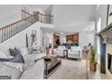 Open floor plan living room with fireplace, hardwood floors, and staircase at 1654 Summersweet Ln, Dacula, GA 30019