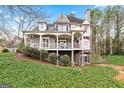 Elegant gray home boasts a spacious porch, stone detailing, and a beautifully landscaped yard at 600 Lake Overlook Dr, Canton, GA 30114