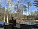 Backyard view with outdoor kitchen, granite countertop, and a scenic lake view at 105 Dockstreet Aly, Peachtree City, GA 30269