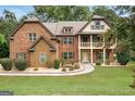Charming two story home with brick and stone exterior and lush landscaped front yard at 105 Dockstreet Aly, Peachtree City, GA 30269