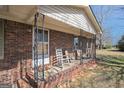 Inviting front porch with traditional rocking chairs and brick foundation at 143 Teamon Rd, Hampton, GA 30228