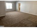 Large, open-plan living area with neutral carpet and bright natural light at 165 Lakeside Pt, Covington, GA 30016