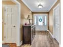 Bright foyer with wood-look floors, a decorative table, and a view of the front door at 3075 Wood Valley Dr, Mcdonough, GA 30253