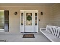 Inviting front porch with a swing and decorative front door at 3075 Wood Valley Dr, Mcdonough, GA 30253