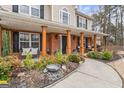 Inviting front porch with brick columns, ample seating, and lush landscaping at 4006 Asheville Ct, Buford, GA 30519