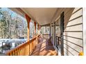 Long, inviting covered porch featuring wood railings and beams, offering an outdoor seating area at 6255 James Rd, Austell, GA 30168