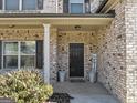 Front porch showcasing the brick facade, black front door, and decorative potted plants at 10736 Southwood Dr, Hampton, GA 30228