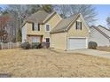 Two-story home with a two-car garage and neutral colored stucco, and nice landscaping at 12241 Crestwood Ct, Fayetteville, GA 30215