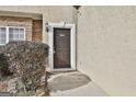 Dark-stained front door with stone facade and green shrubbery at 12241 Crestwood Ct, Fayetteville, GA 30215