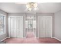 Spacious bedroom with large closets and a window; light gray walls and pink carpet at 149 Crown Oaks Dr, Stockbridge, GA 30281