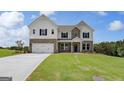 Charming two-story home featuring brick accents, a spacious two-car garage, and meticulously manicured lawn at 127 Felicity Pike, Locust Grove, GA 30248