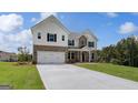Striking two-story home boasting a brick and shingle exterior, a spacious two-car garage, and a pristine lawn at 127 Felicity Pike, Locust Grove, GA 30248
